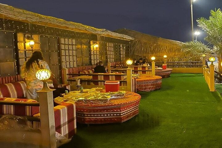 Experience the essence of desert evenings with a BBQ dinner under the stars surrounded by cozy seating and traditional decor perfect for creating unforgettable memories in Dubai.
